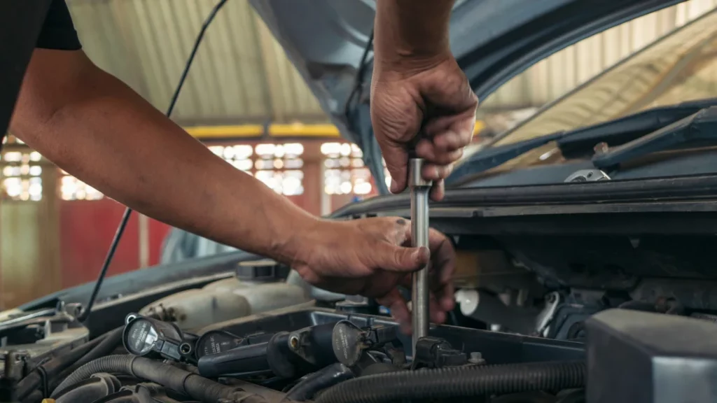 A man diligently repairs a car engine, showcasing his skills in auto repair.