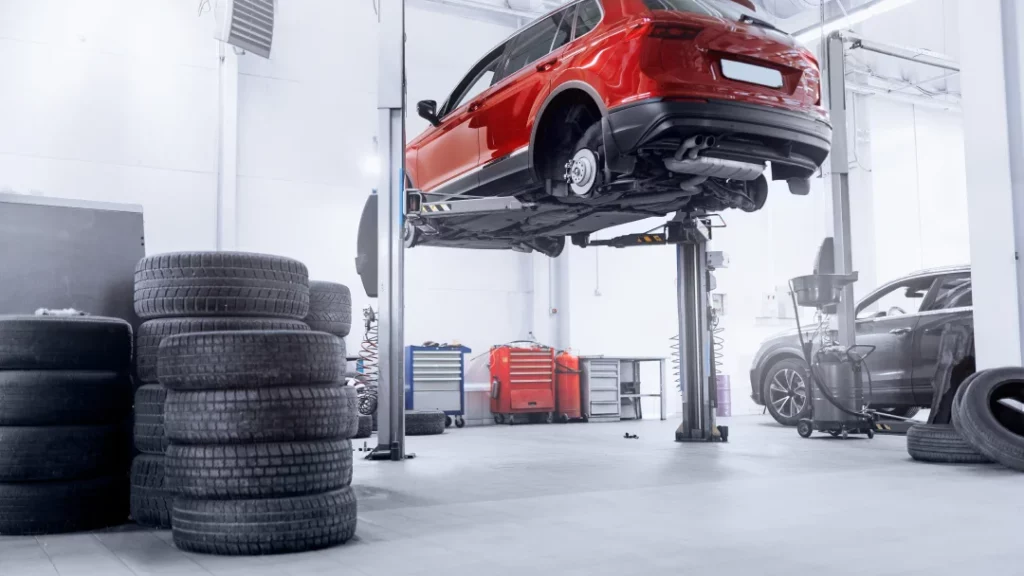 A car is elevated on a lift in a garage, showcasing a car diagnostics service in progress.