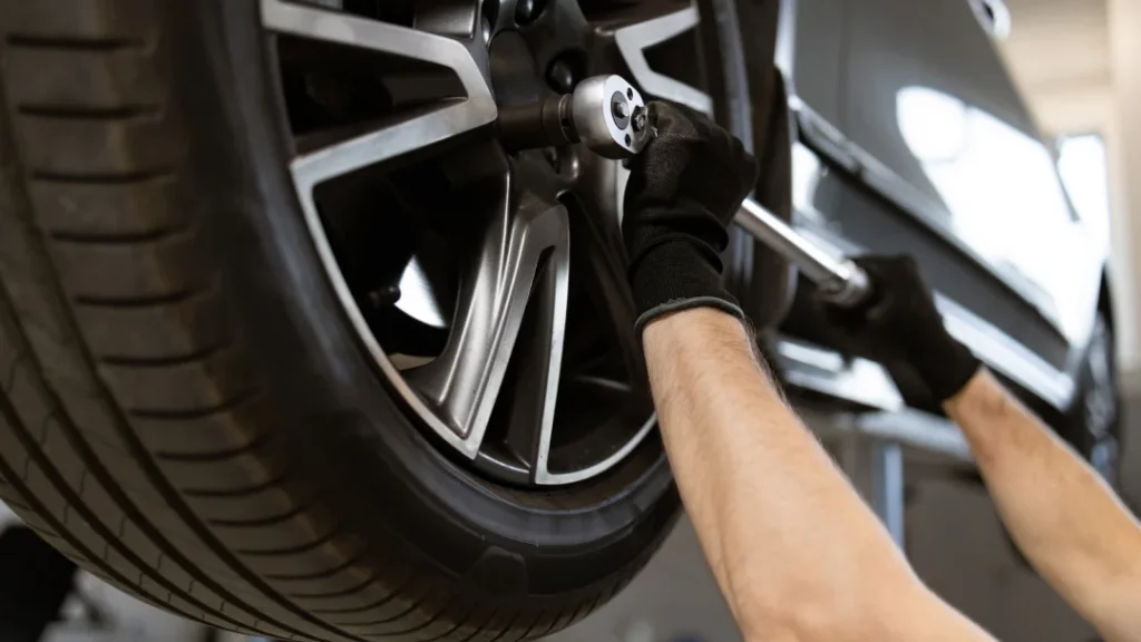 A man is repairing a car tire, focused on ensuring it is properly fixed and safe for use.