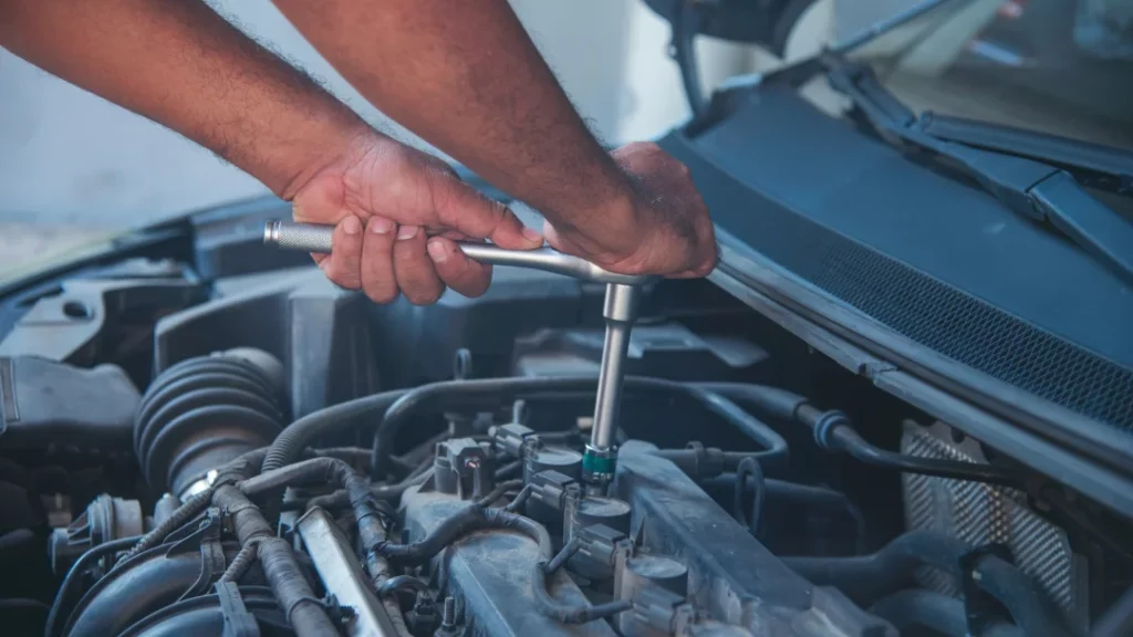 A man is replacing a flat tire on a car, demonstrating essential tire change skills and vehicle maintenance.