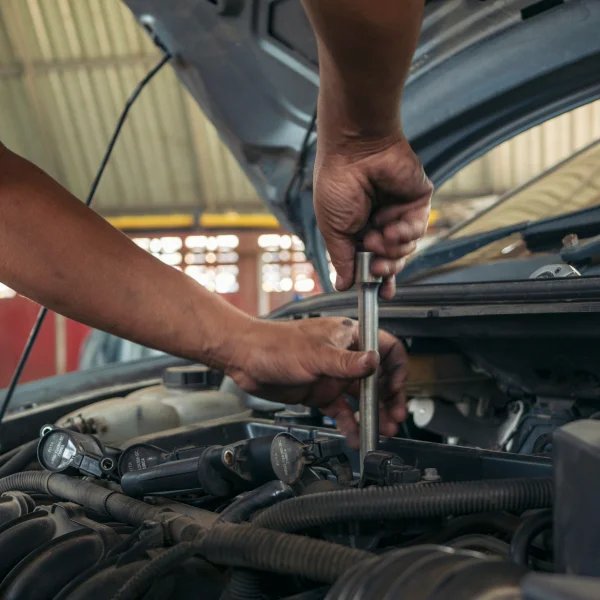 A mobile mechanic repairs a car engine, demonstrating expertise in automotive maintenance and repair.