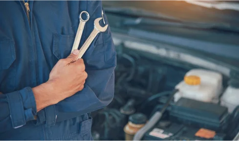 A mobile mechanic in white gloves repairs a car engine, demonstrating expertise and attention to detail.